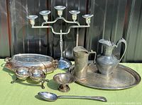 Group shot showing all silver-plated items, pewter pitcher, trays and flatware