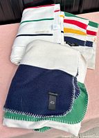 Three folded striped blankets showing colour patterns and stitching