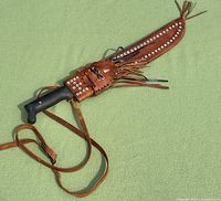 Machete secured inside decorative studded leather sheath with strap
