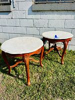 Both matching marble-top side tables outdoors, showing overall design and condition