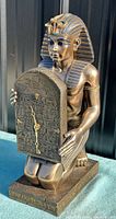 Front view of Tutankhamun statue holding clock tablet