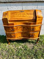 Full frontal view of bombe-front secretary desk showing drawers, legs and closed fall front