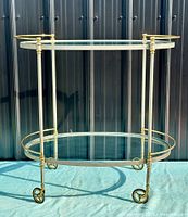 Full view of bar cart showing both glass shelves, metal frame and casters