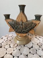 Front view showing butterfly relief, glaze colors, pedestal base