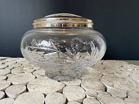 Side view of crystal rose bowl with metal frog lid attached