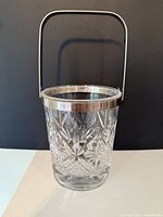 Front view of cut crystal ice bucket with handle raised