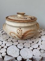 Casserole dish with lid, front view showing wheat motif and side handles