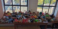 Table filled with over 100 assorted TY Beanie Babies plush toys