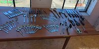 Wide view of table with flatware, knives and assorted kitchen tools