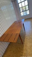 Side view of teak dining table with both leaves inserted