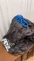 Full view of Petzl Bolsa rope bag with blue rope and GriGri device visible