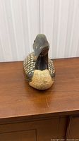 Front view of carved wooden loon showing breast, head and red eyes