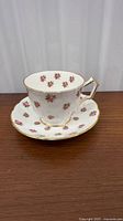 Teacup on saucer showing floral pattern and gold trim