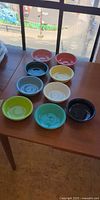 Nine assorted color Fiesta bowls on table.