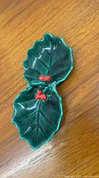 Top view of green ceramic double holly leaf dish with red berry detail