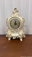 Front view of ornate cream Lanshire electric mantel clock showing dial and decorative case