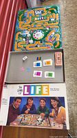Open box showing game board, spinner, cards, money, cars, tray