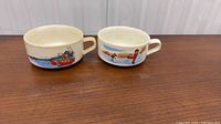 Front view of both mugs showing graphics