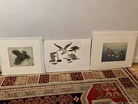 Overview of three matted unframed prints leaning against wall