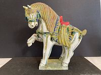 Full view of ceramic horse figurine showing colors, stance, and base