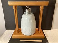 Bell hanging on wooden stand with striker in front