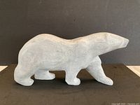 Side view of full stone polar bear sculpture