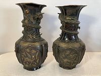 Front view of both bronze vases showing overall form and relief decoration