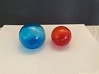 Blue and red glass floats side by side