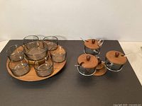 two teak serving pieces with glass bowls displayed