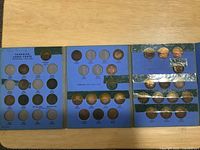 Full view of tri-fold folder open with coins in wells