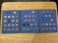 Entire tri-fold album opened showing three panels with coins