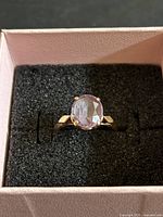 Top view of 10k gold ring with oval amethyst seated in jewellery box