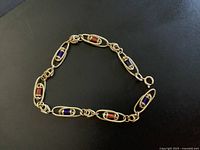 Bracelet laid in oval shape showing alternating red and blue stones