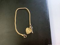 Full view of gold-filled snake chain bracelet with heart and key charms