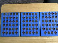 All three blue Whitman coin boards opened showing filled slots