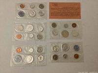 Five sealed 1964 proof sets laid out