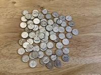 Pile of 1967 Canadian silver dimes on wood surface