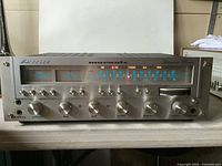 Front panel powered on showing illuminated dial, meters and controls