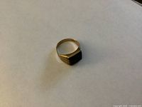 Top view of gold ring with black onyx face
