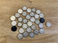 All 32 1968 Canadian quarters spread on wood surface