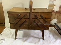 closed wooden accordion sewing box on legs