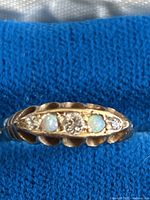 Ring top view showing alternating opals and diamonds in scalloped bezel