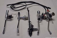 Group shot of five tonearms and two cables