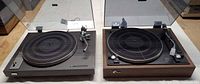 Both Sansui turntables side by side showing plinths, platters and dust covers