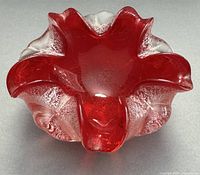 Top view showing red glass bowl with wavy lobes and silver flecks