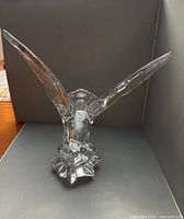 Front angled view of clear crystal eagle with wings spread, showing overall form and clarity
