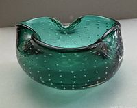 Front angled view showing green glass bowl with controlled bubbles and tri-lobed rim
