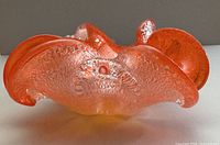 Front view of orange ruffled art glass bowl