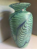 Front view of aqua art glass vase with blue spiral pattern and flared rim