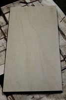 Single beige porcelain tile sample showing color, surface and size